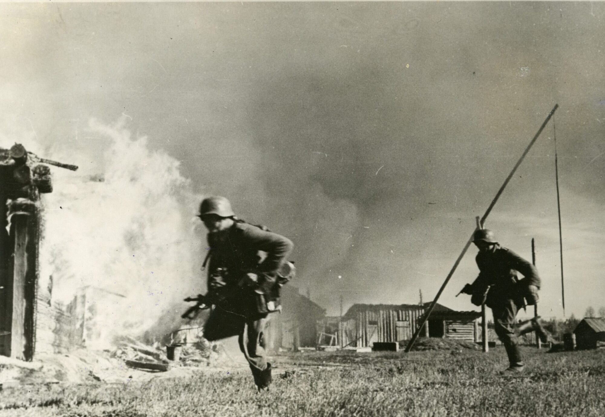 Fotografia storica di soldati che corrono tra il fumo e le fiamme