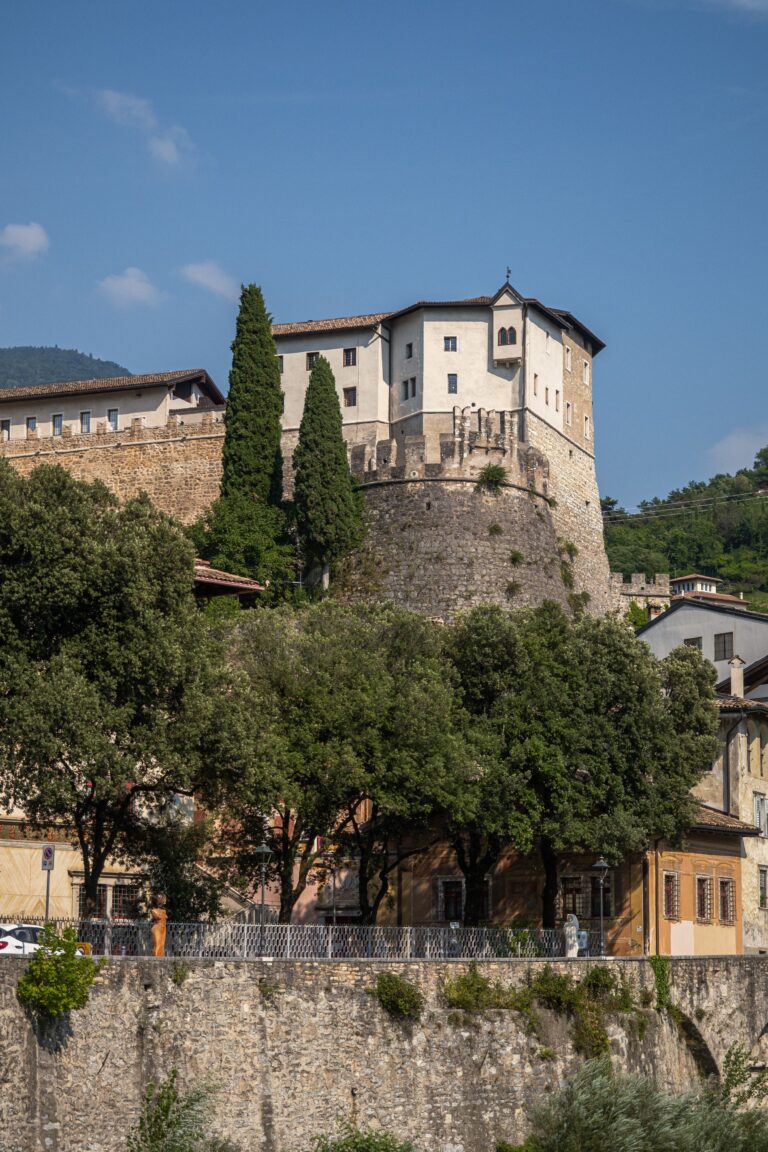 Il Castello di Rovereto visto dal basso, tra alberi e cipressi