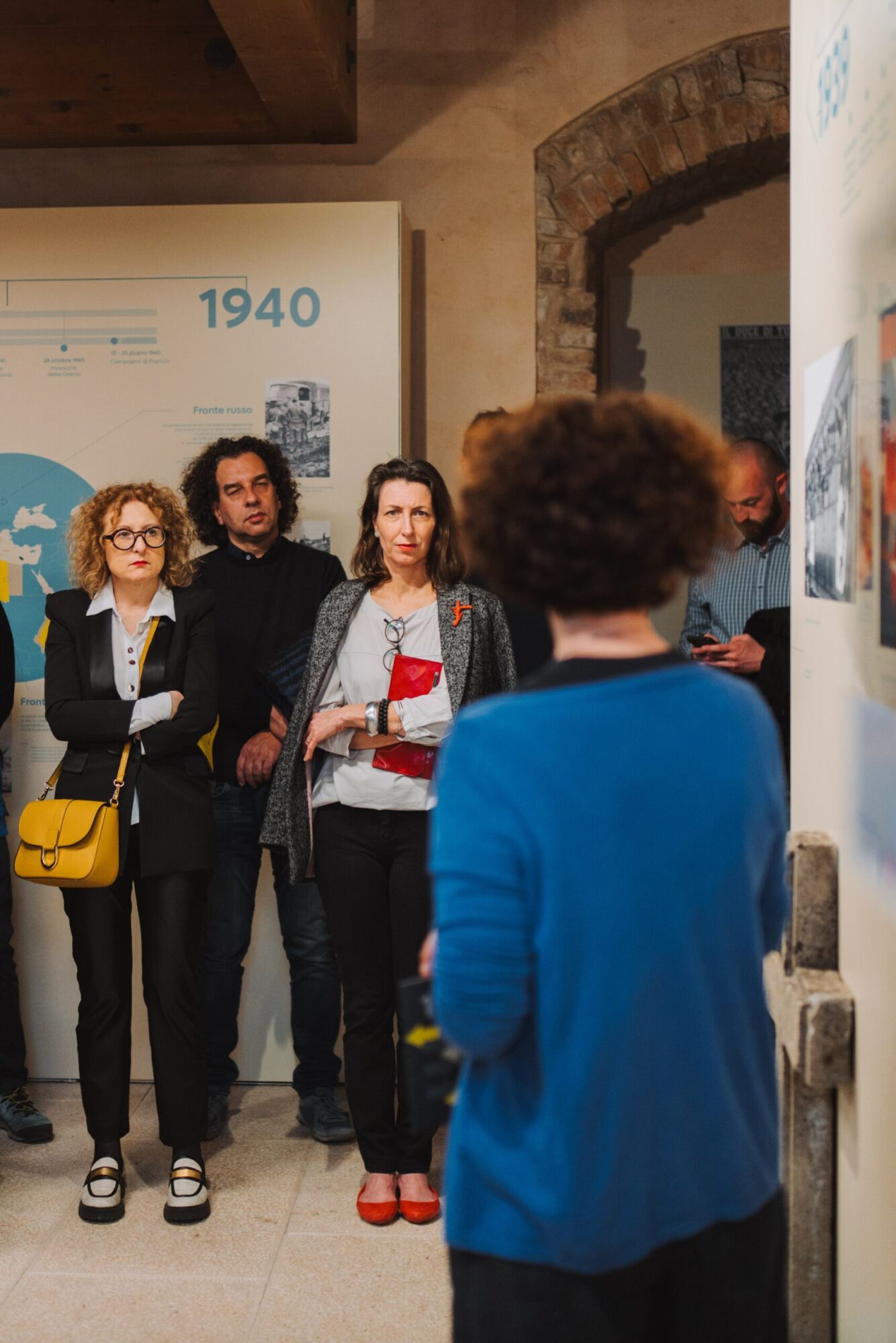 Gruppo di visitatori ascolta una guida in una sala del museo