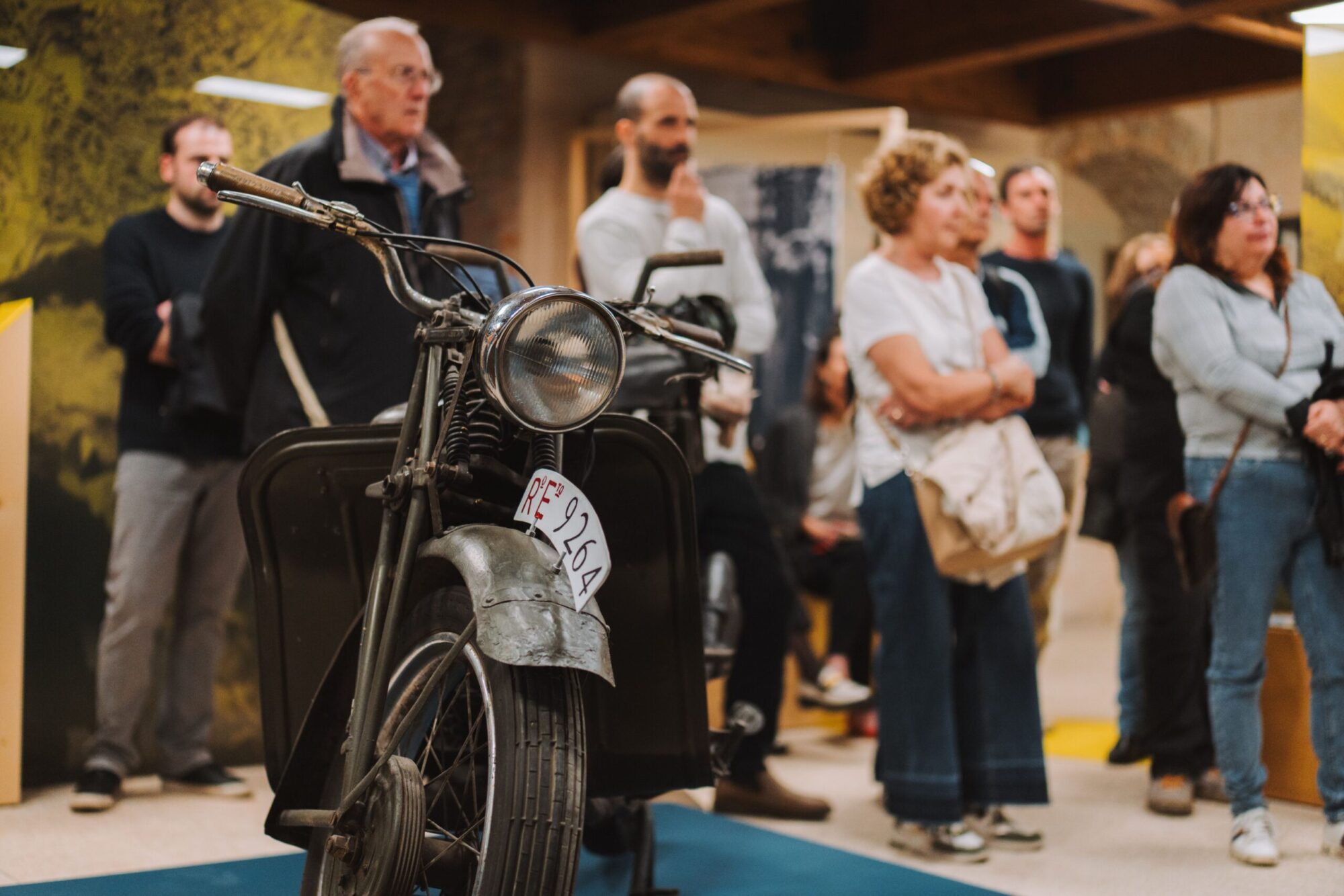 Gruppo di adulti in visita guidata accanto a una motocicletta militare d'epoca