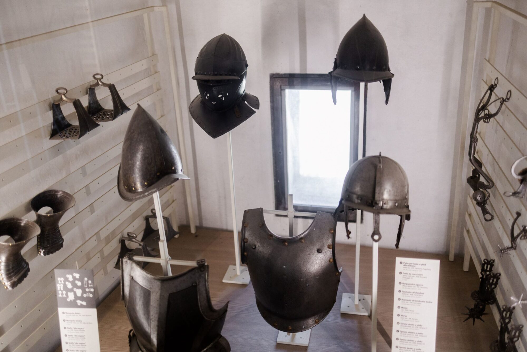 Elmi e parti di armatura antichi esposti in una sala del Castello