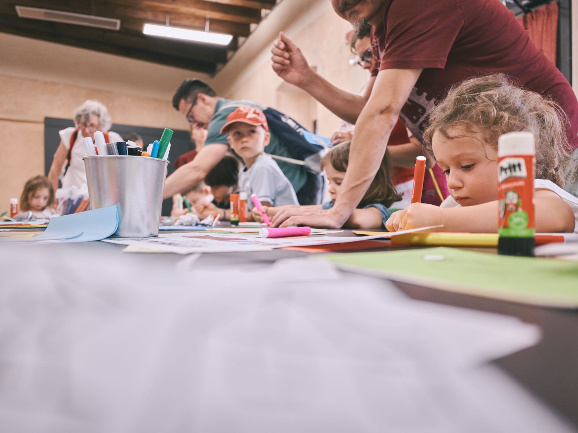 Bambini disegnano e incollano durante un laboratorio per famiglie