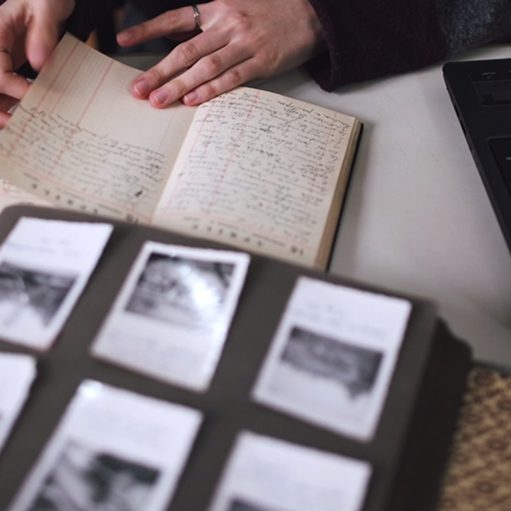 Mani che sfogliano un album di fotografie e un quaderno manoscritto d'archivio