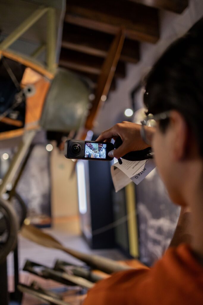 Studente fotografa con lo smartphone un oggetto in esposizione