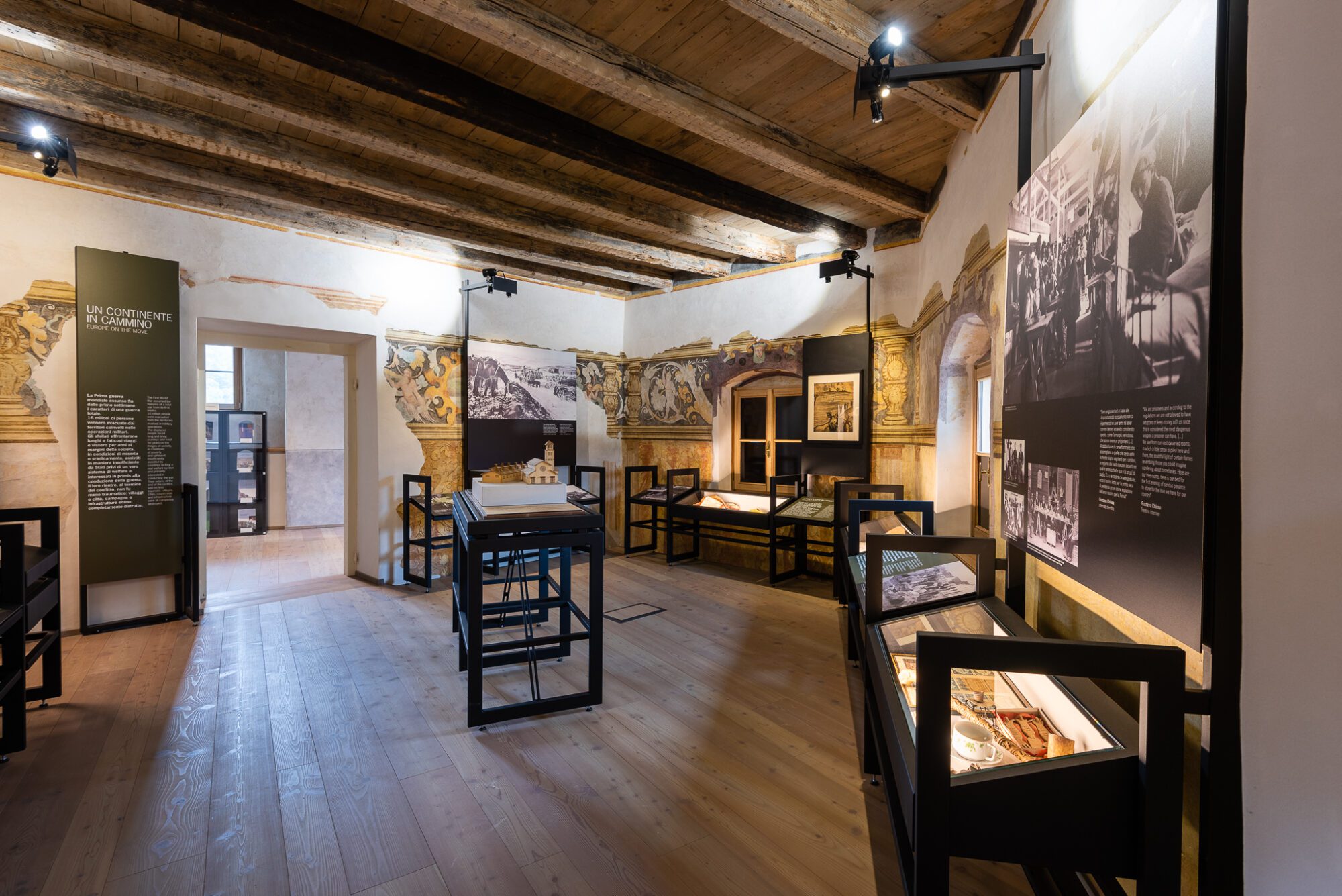 Sala del museo con soffitto in legno, vetrine e pannelli espositivi