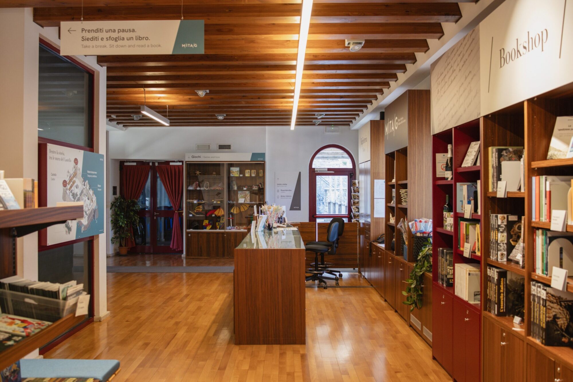 Il bookshop del MITAG con scaffali di libri e soffitto in legno