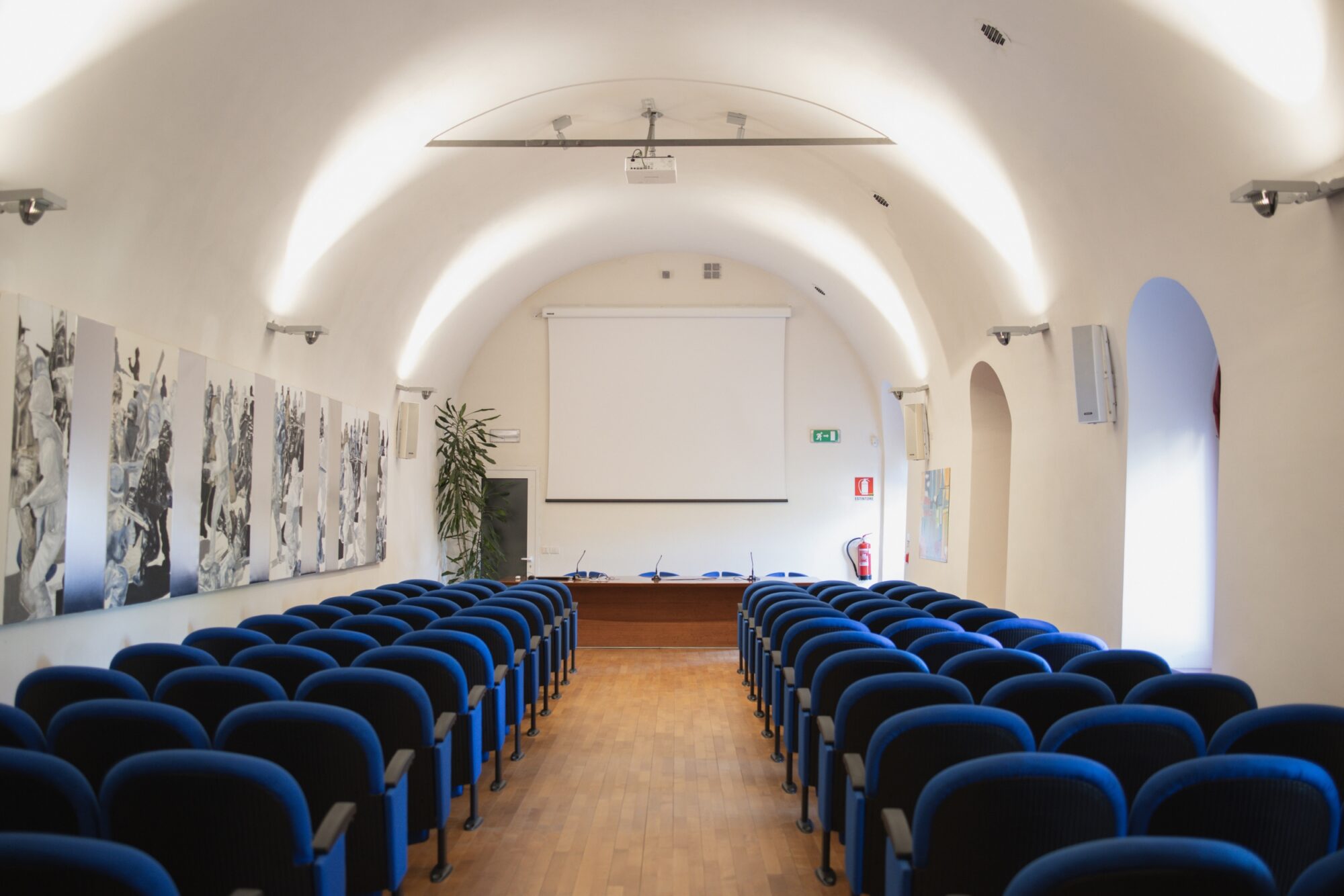 Sala Conferenze del MITAG con file di poltroncine blu e volta a botte