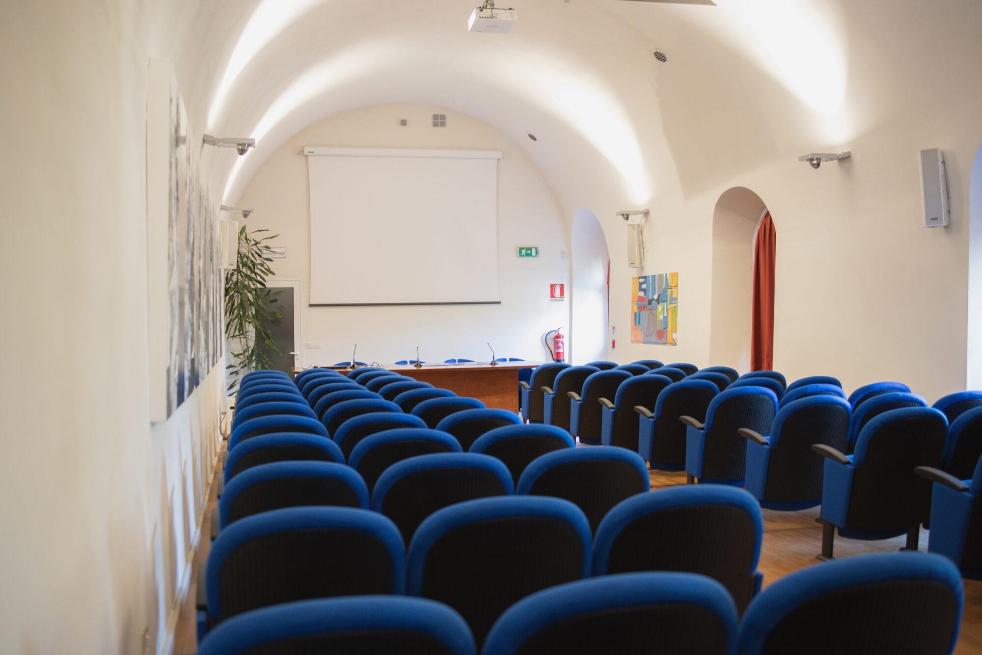 Sala Conferenze del MITAG vista dal fondo, con lo schermo per le proiezioni