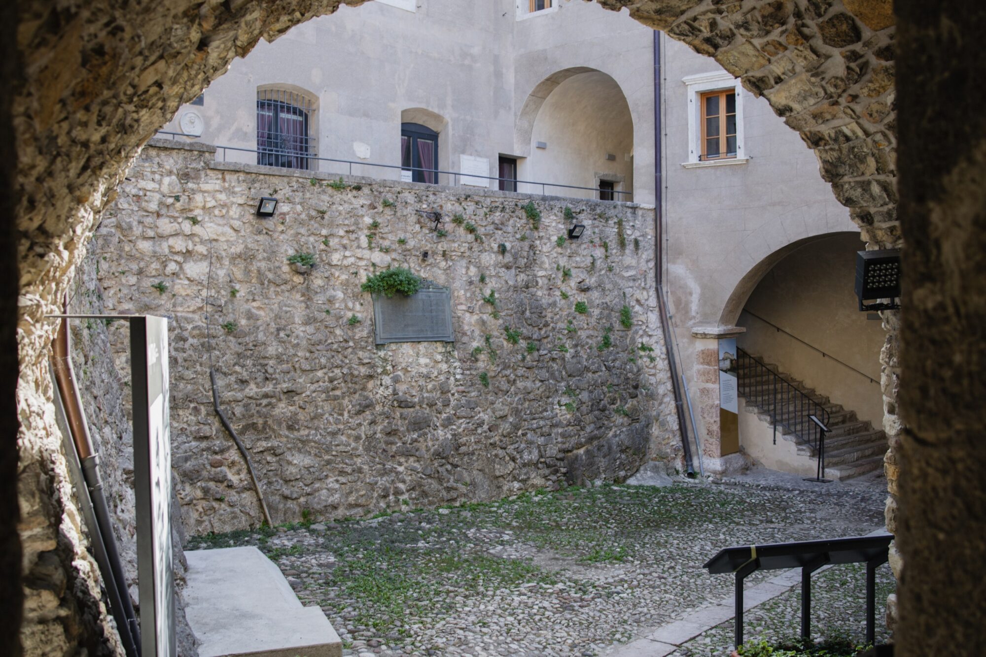 Cortile del castello visto attraverso un arco in pietra